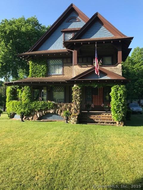 back of property featuring a porch and a lawn