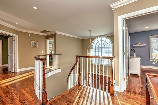 staircase with ornamental molding and hardwood / wood-style floors