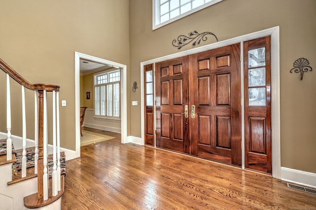 entryway featuring hardwood / wood-style flooring and a high ceiling