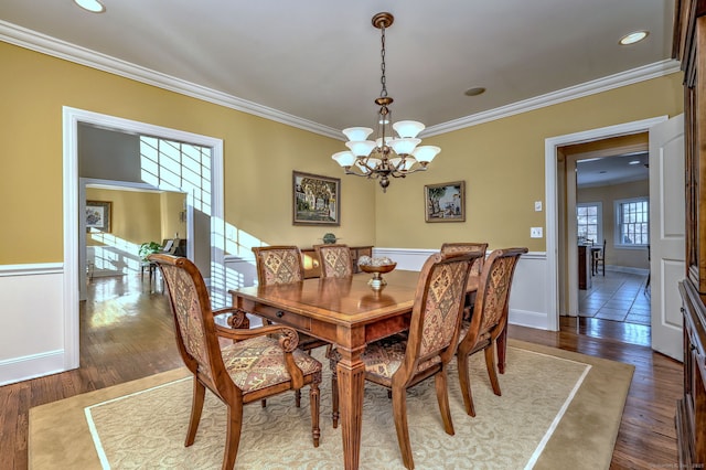 dining space with crown molding, dark wood-type flooring, and a notable chandelier