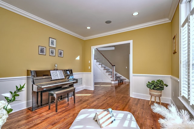 living area featuring hardwood / wood-style flooring and crown molding