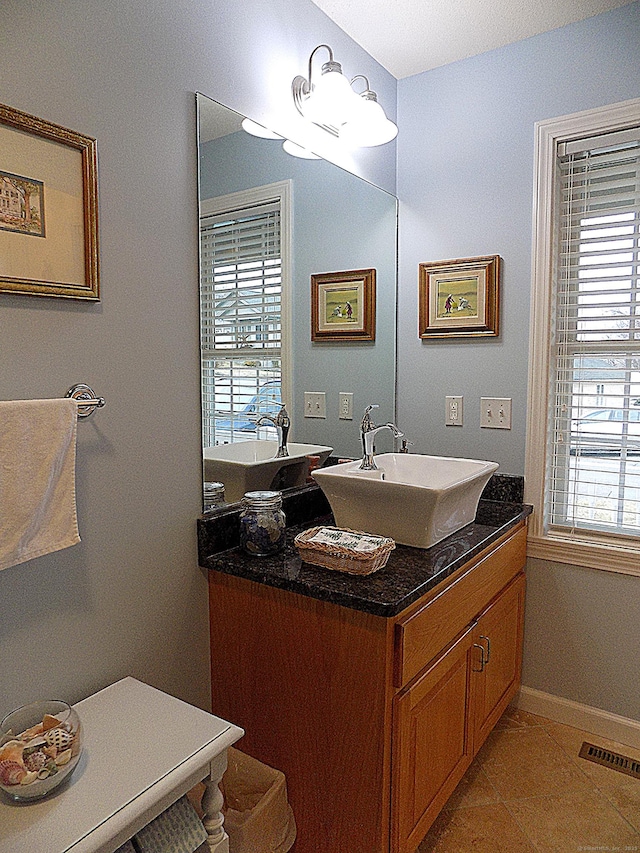 bathroom featuring a wealth of natural light, tile patterned floors, and vanity