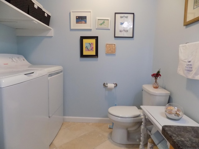 bathroom with tile patterned flooring, washing machine and dryer, and toilet