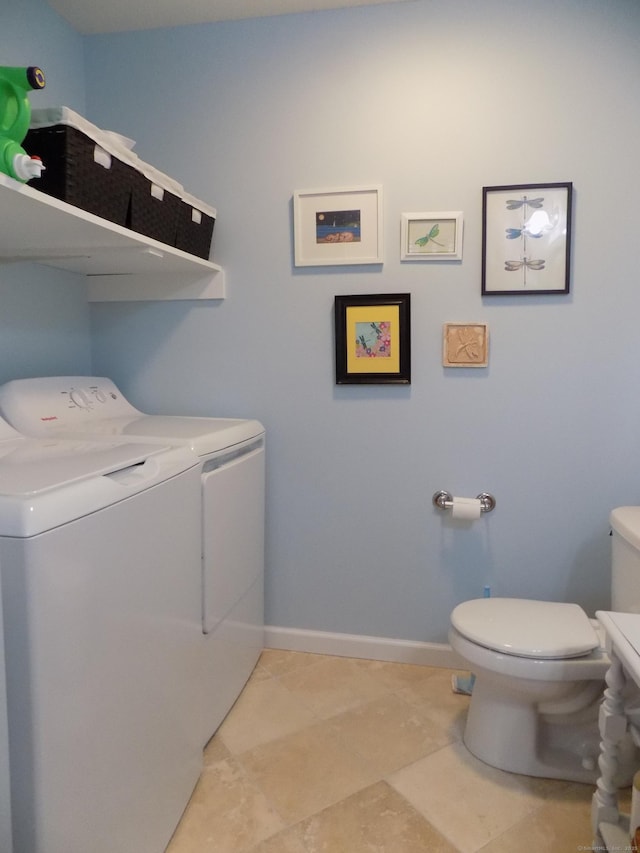 laundry room with washer and clothes dryer and light tile patterned floors