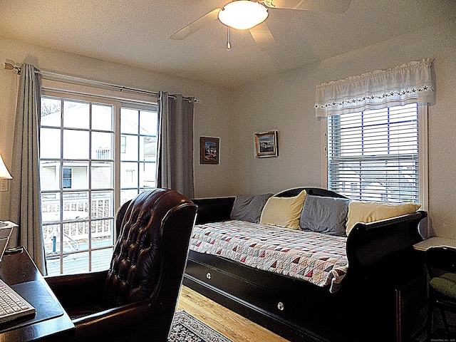 bedroom with ceiling fan, hardwood / wood-style floors, and multiple windows