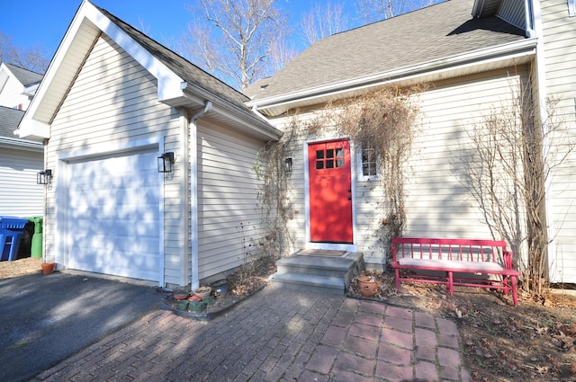 property entrance featuring driveway and a shingled roof