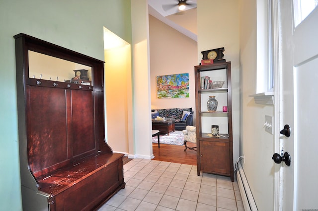 interior space with a baseboard heating unit, light tile patterned flooring, and baseboards