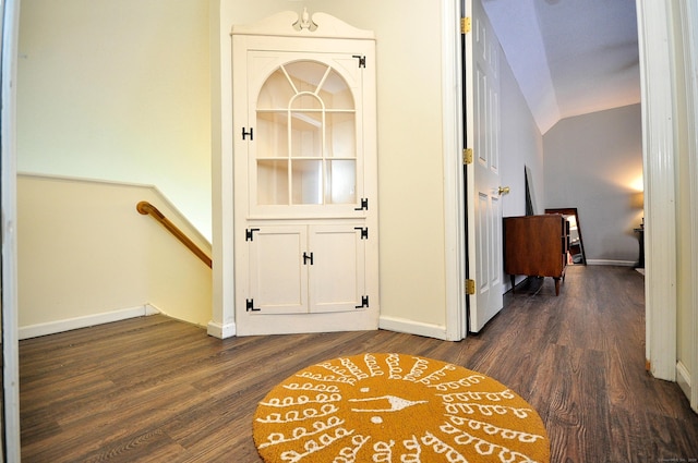 corridor with lofted ceiling and dark hardwood / wood-style floors