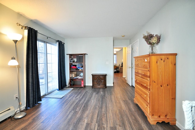 interior space featuring a baseboard heating unit, dark wood-type flooring, and baseboards