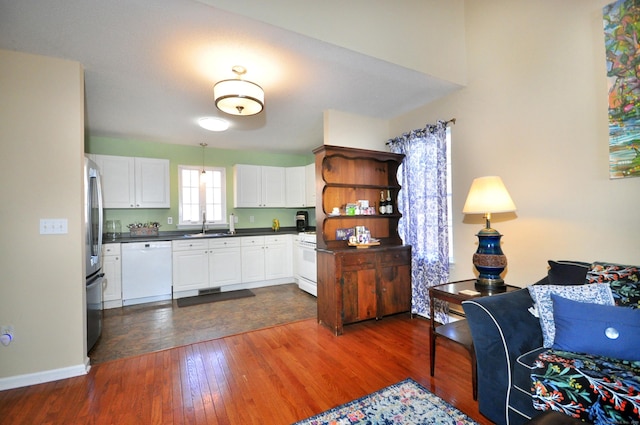 kitchen featuring sink, white appliances, dark hardwood / wood-style floors, and white cabinets