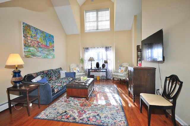 living room with baseboards, high vaulted ceiling, and wood finished floors