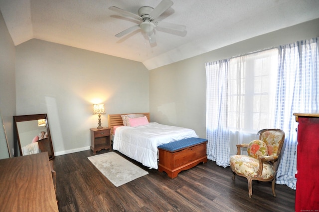 bedroom featuring dark wood-type flooring, vaulted ceiling, and ceiling fan