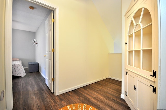 hallway with dark wood finished floors and baseboards