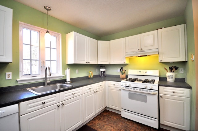 kitchen featuring under cabinet range hood, white appliances, a sink, white cabinets, and dark countertops