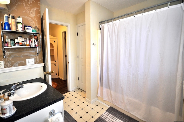 full bathroom featuring a shower with shower curtain, vanity, baseboards, and tile patterned floors