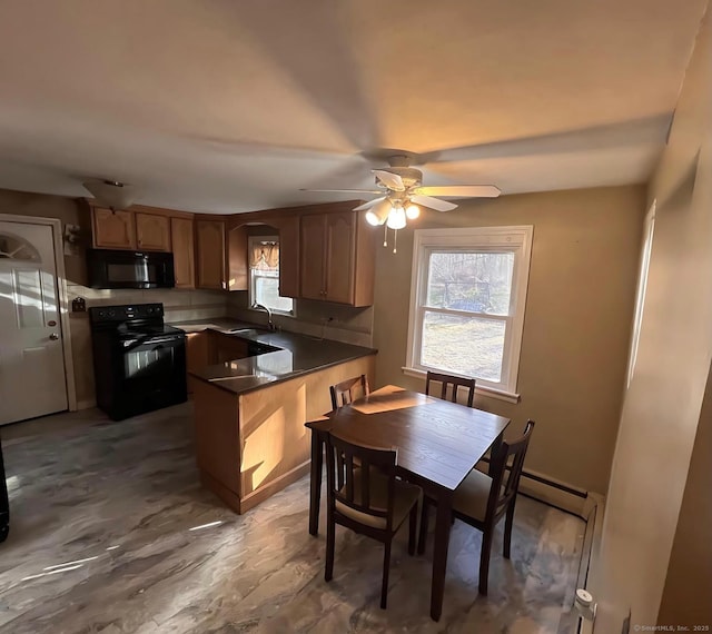 kitchen with kitchen peninsula, baseboard heating, ceiling fan, sink, and black appliances