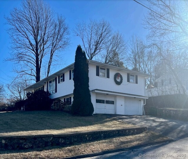 view of side of home featuring a lawn and a garage