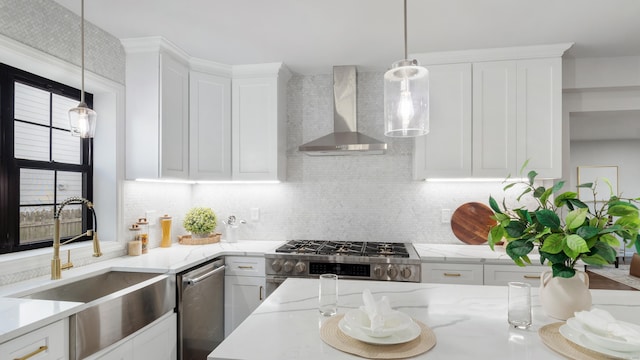 kitchen featuring stove, wall chimney range hood, and white cabinets