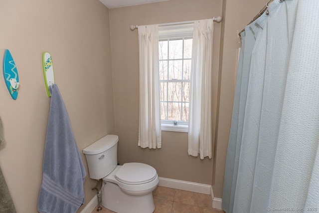 bathroom featuring toilet, tile patterned flooring, and baseboards