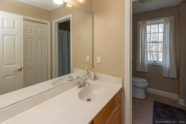 full bath featuring a closet, toilet, vanity, tile patterned flooring, and baseboards