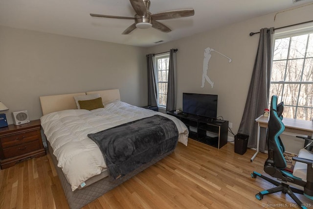 bedroom with light wood-style flooring, visible vents, and a ceiling fan