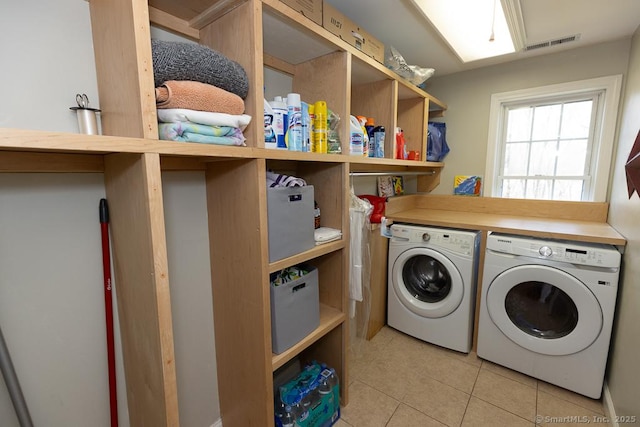 laundry room featuring laundry area, visible vents, separate washer and dryer, and light tile patterned flooring