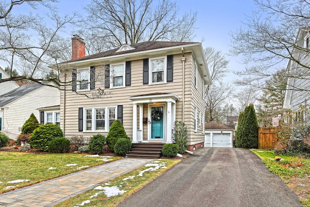 view of front of house with a garage, a front lawn, and an outdoor structure