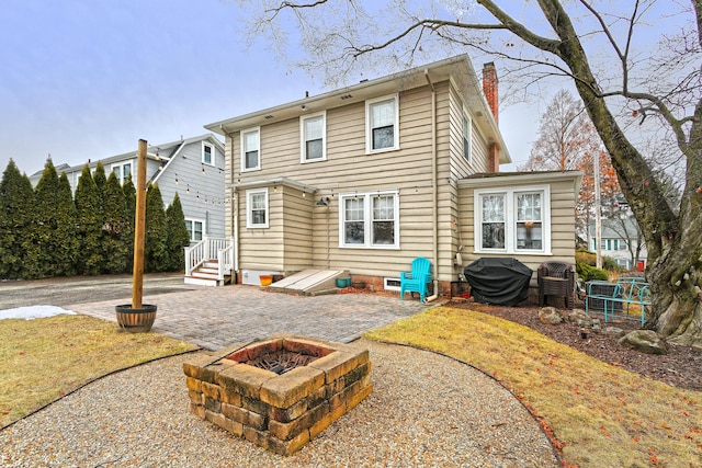 rear view of house featuring a patio area and a fire pit