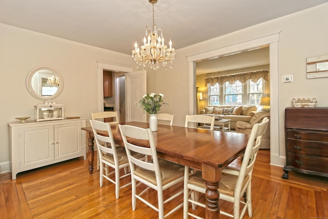 dining space with hardwood / wood-style flooring and a chandelier