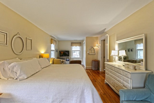 bedroom with wood-type flooring and multiple windows