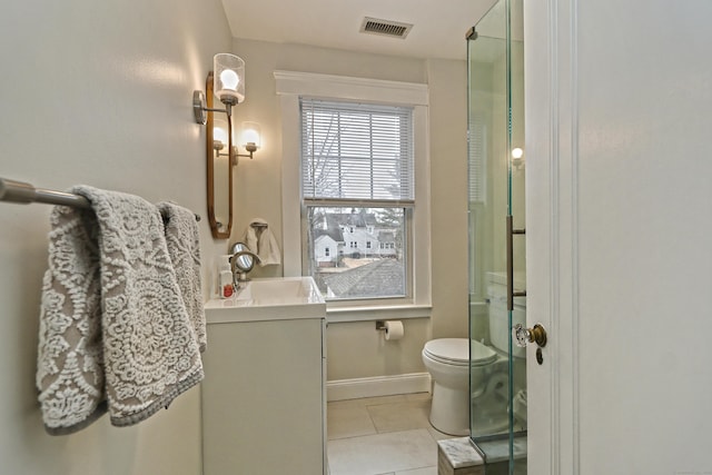 bathroom with toilet, tile patterned flooring, a shower with shower door, and vanity