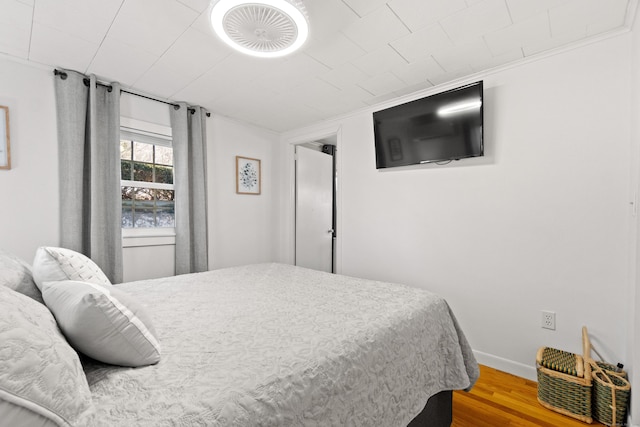 bedroom featuring baseboards and wood finished floors