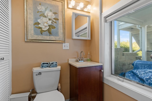 half bathroom featuring vanity and toilet