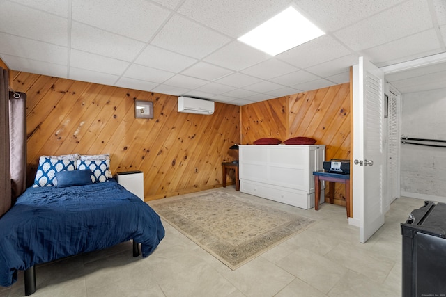 bedroom featuring a paneled ceiling, a wall unit AC, and wooden walls