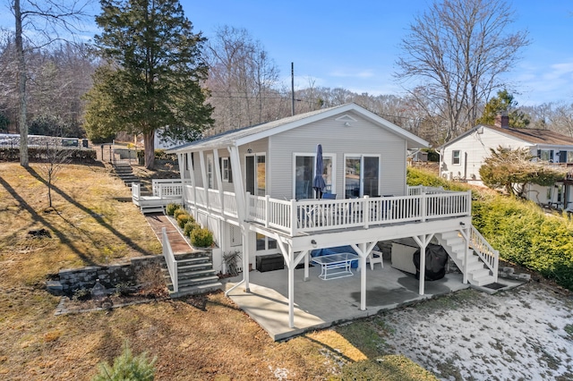 rear view of house with a deck, a patio, and stairway