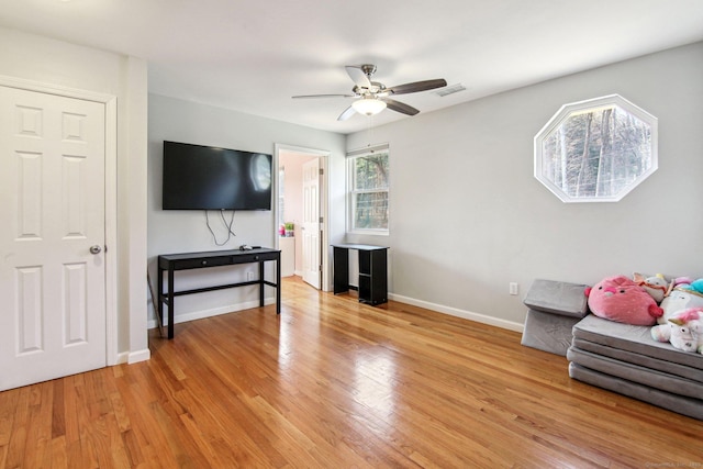 living room with ceiling fan and light wood-type flooring