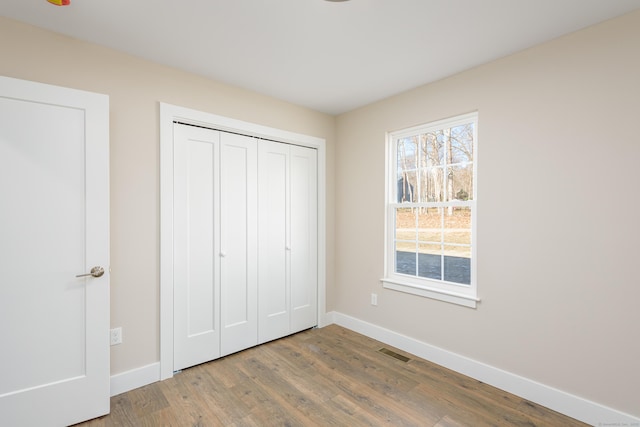 unfurnished bedroom featuring hardwood / wood-style flooring and a closet