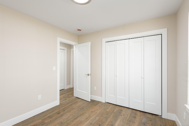 unfurnished bedroom featuring dark wood-type flooring and a closet