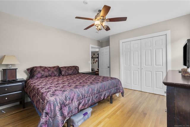 bedroom with ceiling fan, a closet, and light hardwood / wood-style flooring