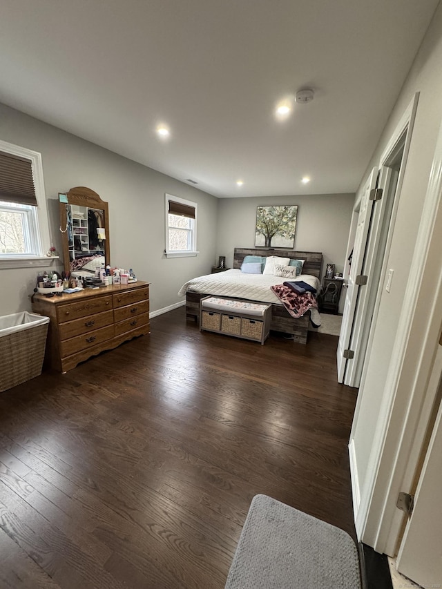 bedroom with dark hardwood / wood-style floors and multiple windows