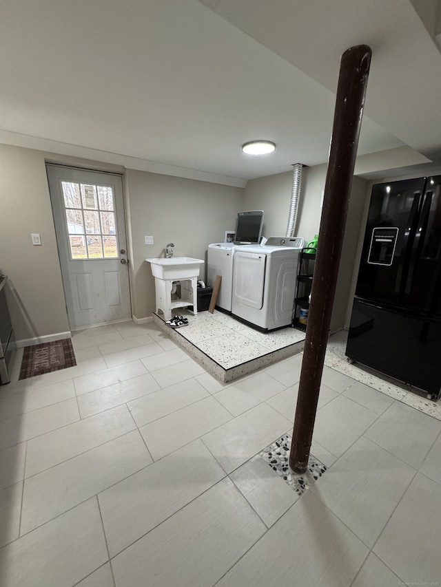 washroom featuring light tile patterned floors, washer and clothes dryer, and sink