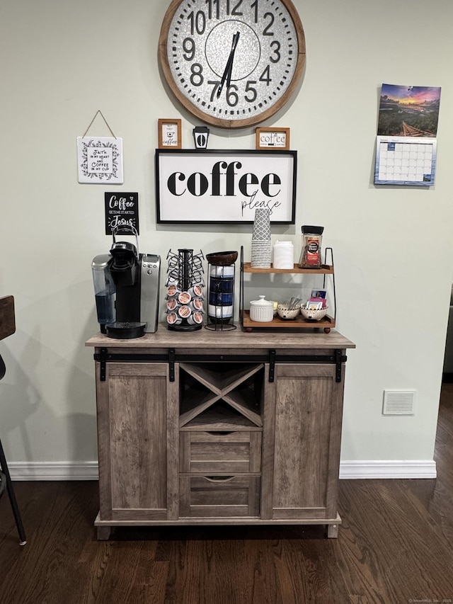 bar with dark wood-type flooring and dark brown cabinetry