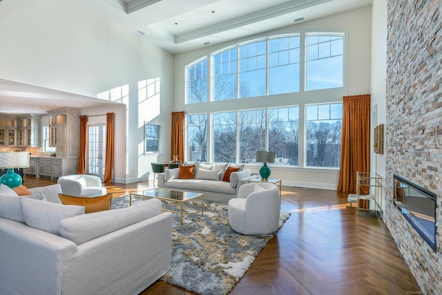 living area with a high ceiling, plenty of natural light, and baseboards