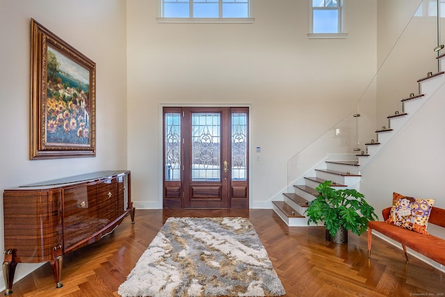 entrance foyer featuring a high ceiling, a healthy amount of sunlight, and stairway