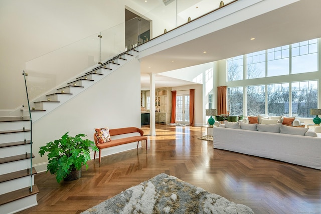 interior space featuring stairway, baseboards, a high ceiling, and recessed lighting
