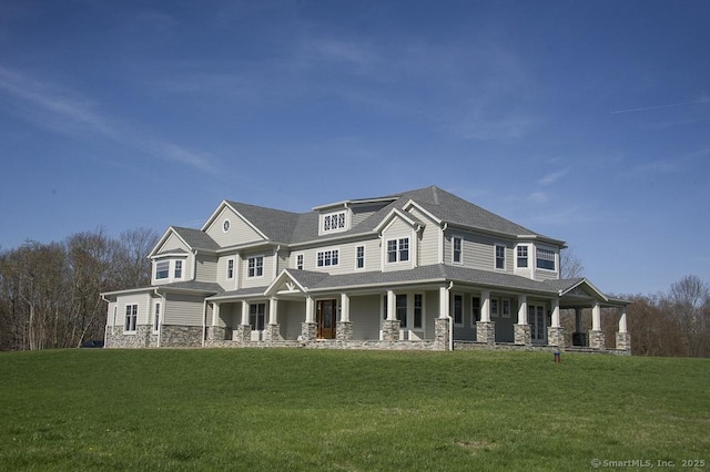 view of front of home with a front yard, a porch, and stone siding