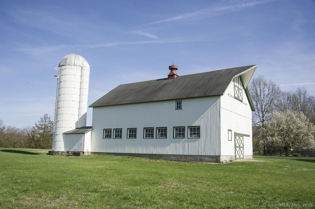 rear view of house with a yard, a barn, an outbuilding, and a chimney