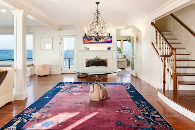 dining area with a water view, dark hardwood / wood-style flooring, a chandelier, crown molding, and beam ceiling