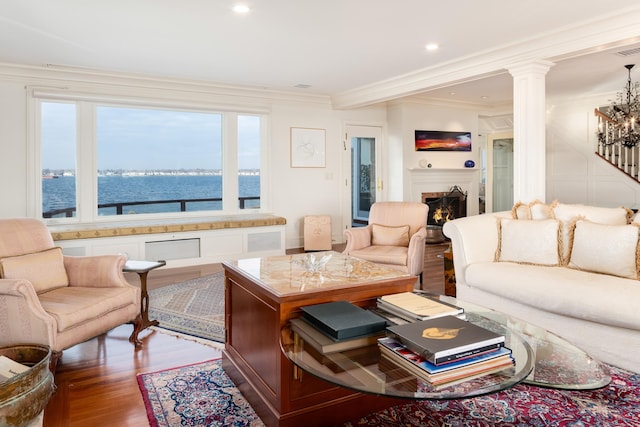 living room featuring a water view, ornamental molding, and hardwood / wood-style flooring