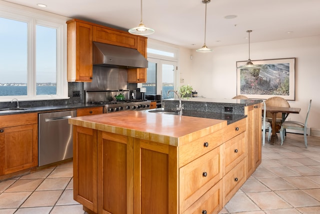 kitchen with dishwasher, wooden counters, a water view, a center island with sink, and range hood